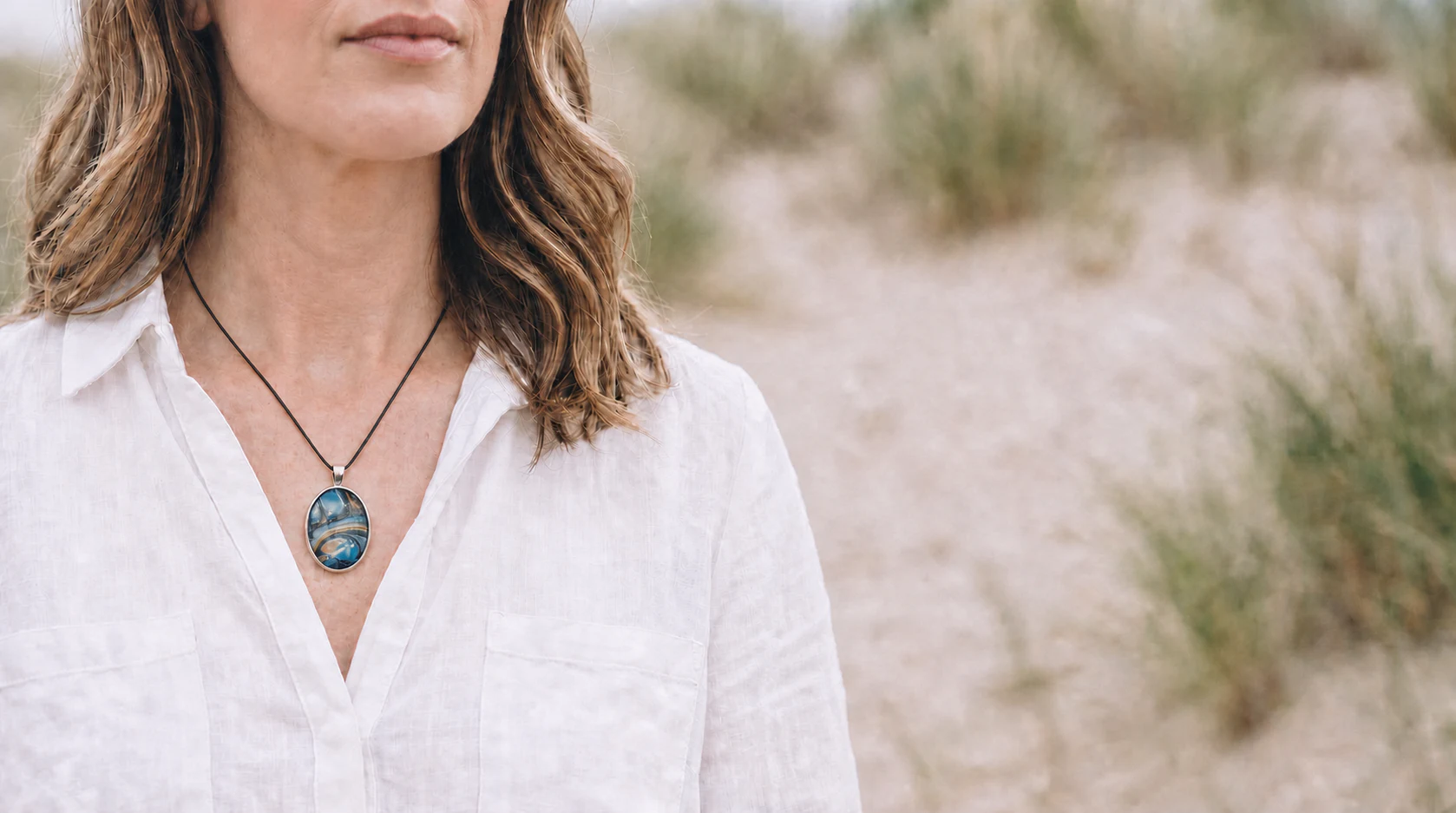 Model wearing a Wild Shore oval fluid art pendant