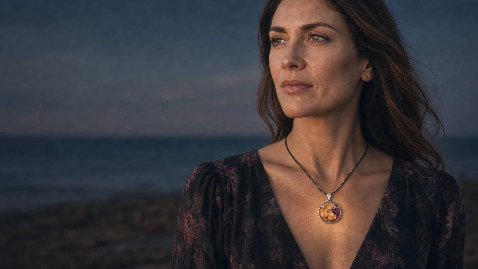 Model wearing a round Wild Shore fluid art pendant on a black cord